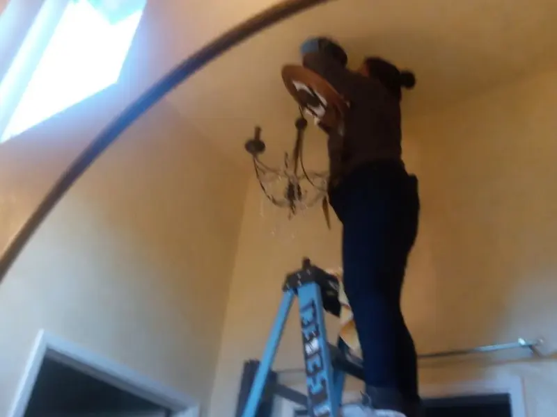 Electrician installing a chandelier in a Moreno Valley residence
